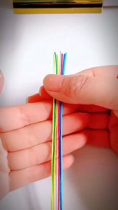 two hands holding multi colored wires in their palm