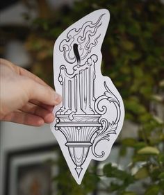 a person holding up a sticker with an image of a lamp post on it