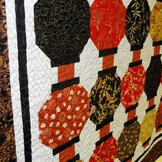 a close up of a quilt on a wall with many different colors and shapes in it