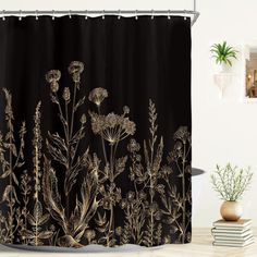 a shower curtain with black and gold flowers on it, next to a potted plant