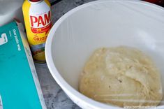 a white bowl filled with batter next to a book