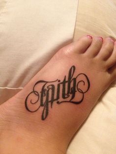 a foot with the word faith tattooed on it's left side, in cursive font