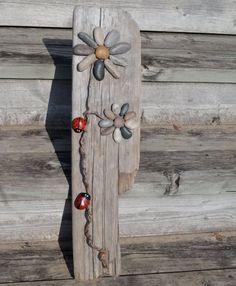 a wooden sign with flowers and ladybugs painted on it's back side