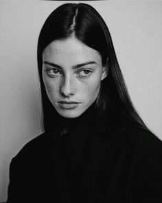 a black and white photo of a woman with long hair wearing a turtle neck sweater