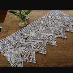 the table is covered with white crocheted doily next to a potted plant