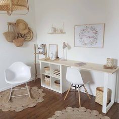 a white desk sitting on top of a wooden floor next to a chair and table