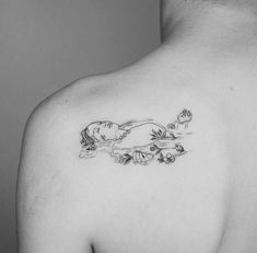 a black and white photo of a man with a tattoo on his back shoulder that has an image of a woman floating in the water