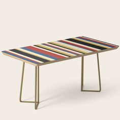 a colorful striped table with gold legs