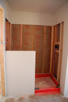 an unfinished room with the door open and walls in place to be built into the wall