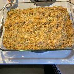 a casserole dish with meat and vegetables in it sitting on a stove top