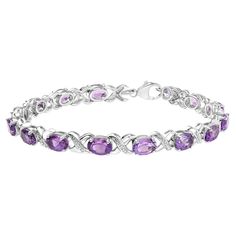 Indulge in the regal splendor of this exquisite .925 sterling silver tennis link bracelet, featuring 15 natural heat-treated purple amethyst gemstones in the oval shape, each measuring 7 x 5mm. The prong setting of each gemstone ensures maximum light exposure, illuminating the rich and captivating purple hues. The bracelet is further adorned with 15 round-cut natural diamonds with a total weight of 0.05 cttw, adding an extra touch of sparkle and shine. The diamonds' H-I color and SI1-SI2 clarity Purple Hues, Sparkle And Shine, Amethyst Gemstone, Purple Amethyst, Gemstone Colors, Sterling Silver Bracelets, Beautiful Bracelet, Diamond White, Oval Shape