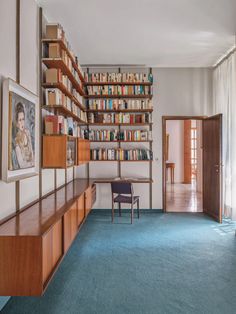 an empty room with bookshelves and blue carpet