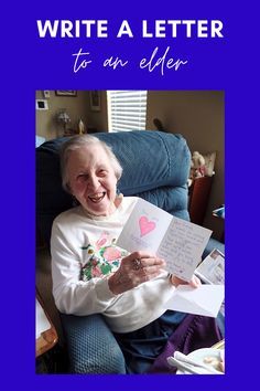 an older woman sitting in a chair holding up some papers and smiling at the camera