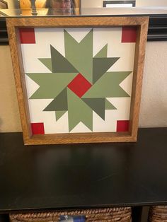 a wooden frame with a green and red star quilt on it next to baskets in front of a mirror