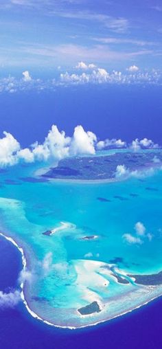 an aerial view of the ocean with clouds and blue water in the foreground, taken from above