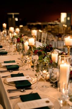 a long table is set with candles and place settings