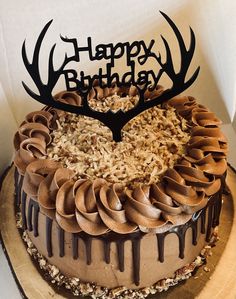 a birthday cake with chocolate frosting and an antlers head on top that says happy birthday