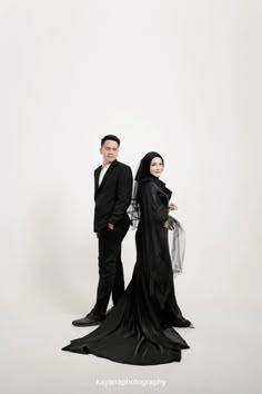 a man and woman dressed in black posing for a photo with one another wearing a veil