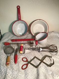 an assortment of kitchen utensils on a bed