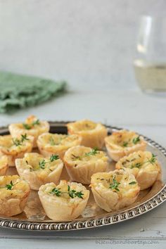 a platter filled with mini quiches on top of a table