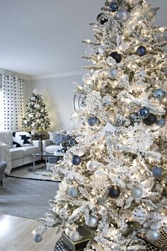 a white christmas tree with black and silver ornaments