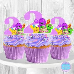 three cupcakes with purple frosting and numbers on them