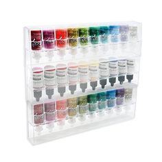 a clear acrylic display with twelve different colors of paint in each container on it