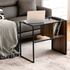 a laptop computer sitting on top of a wooden table next to a couch in a living room