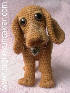 a crocheted dog with big eyes and a heart in it's mouth