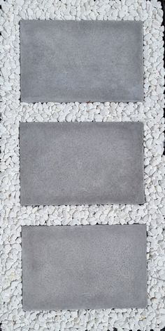 a white and grey rug with two rectangles on top of each other in front of a black background