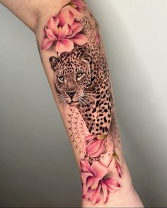 a woman's arm with a leopard and flowers on it