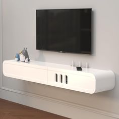 a flat screen tv mounted to the side of a white entertainment center in a living room