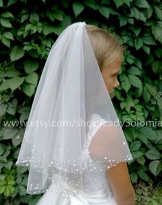 This is a beautiful and gentle two tier First Communion Veil with a crystals and pearls the edge of the veil is decorated with a scattering of small crystals and pearls. Comes with metal comb at the top of the veil to secure it on the head. If you have any questions please send me a message, I will be happy to help. READY TO SHIP! 2 layers: 18&22 (45&55cm) * Available color: white, light ivory If you need fast delivery, the ad has the option to choose express delivery UPS 5-6 days. First Communion Hairstyles With Veil, First Communion Hairstyles, Flower Girl Veil, Girls Veiled, Communion Hairstyles, Catholic Veil, First Communion Veils, Communion Veils, Beaded Veils