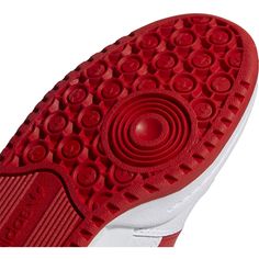 red and white tennis shoes with the soles on it's outstep