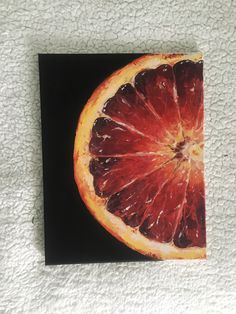 an orange cut in half sitting on top of a black and white piece of paper