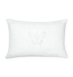 a white pillow with a butterfly embroidered on the front and back, sitting against a white background