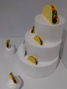 there is a three tiered cake with tacos on the top and other decorations around it