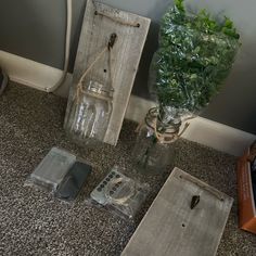 three glass vases with flowers in them sitting on the floor next to some tags