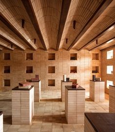 the interior of a building with wooden walls and floor tiles on the wall, along with white pedestals