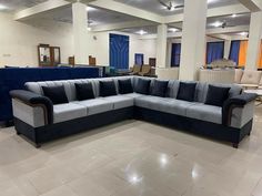 a blue and grey sectional couch in a large room with chairs on the other side