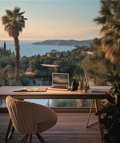 a laptop computer sitting on top of a wooden desk next to a palm tree covered hillside