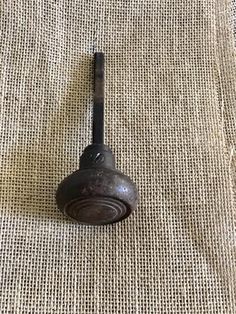 an old metal object sitting on top of a burlied cloth covered tablecloth