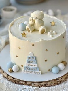 a baby shower cake with a teddy bear sitting on it's top and stars around the edges