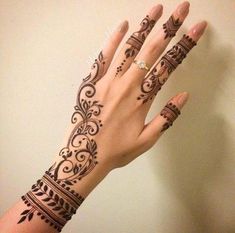 a woman's hand with henna tattoos on it