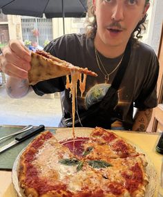 a young man is eating a deep dish pizza