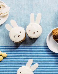 three cupcakes with white frosting decorated like bunnies and two bunny ears