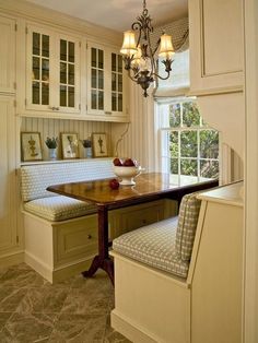 a kitchen area with a table, bench and cabinets in it's center island