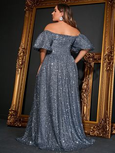 a woman standing in front of a mirror wearing a dress with sequins on it