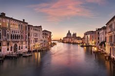 the sun is setting in venice, italy as seen from the bridge over the grand canal