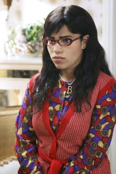 a woman wearing glasses and a red sweater